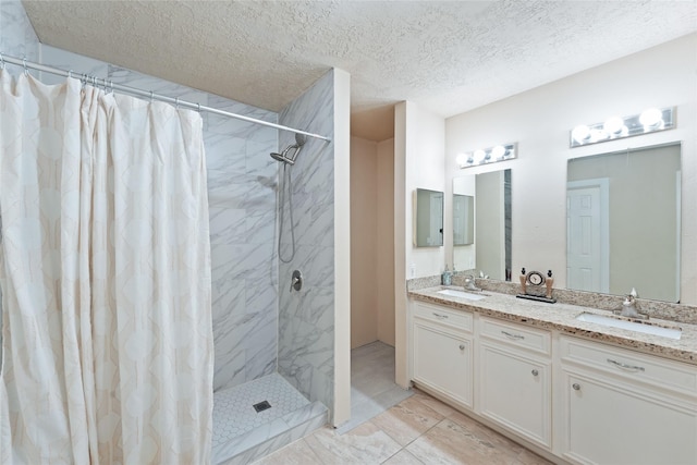 full bath with double vanity, a textured ceiling, a shower with curtain, and a sink