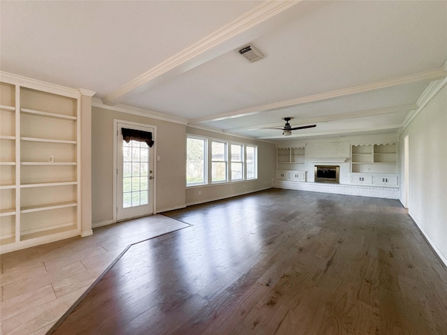 unfurnished living room with wood finished floors, visible vents, beam ceiling, ceiling fan, and a brick fireplace