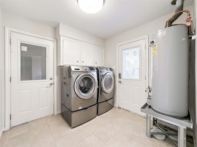 laundry room with light tile patterned floors, cabinet space, water heater, and washer and clothes dryer