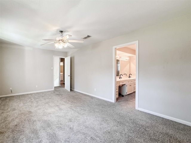 unfurnished bedroom with baseboards, visible vents, ensuite bath, ceiling fan, and carpet flooring