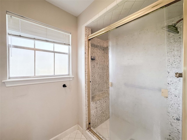 bathroom featuring a shower stall, baseboards, and tile patterned floors