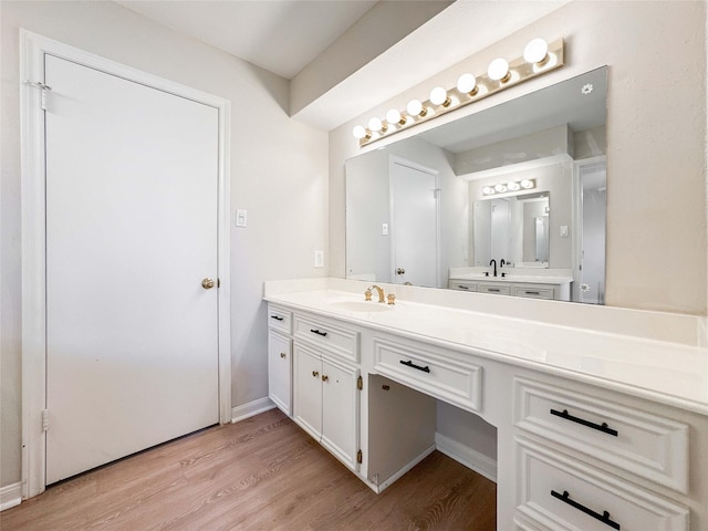 bathroom featuring vanity, baseboards, and wood finished floors