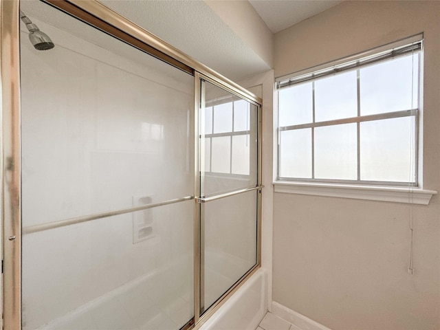 full bath with combined bath / shower with glass door and baseboards