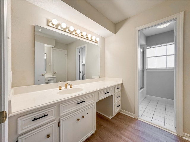 full bathroom with tub / shower combination, baseboards, wood finished floors, and vanity