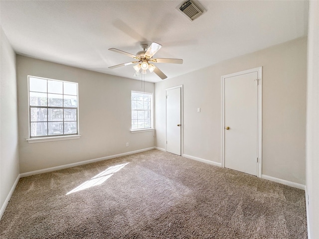 unfurnished bedroom with visible vents, baseboards, carpet, and a ceiling fan