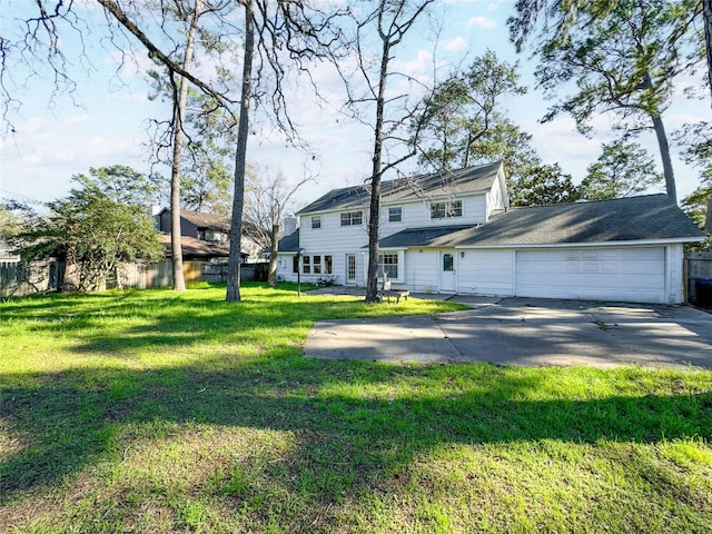 view of front facade with a garage, concrete driveway, a front lawn, and fence