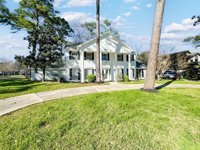 greek revival house featuring a front lawn and stucco siding