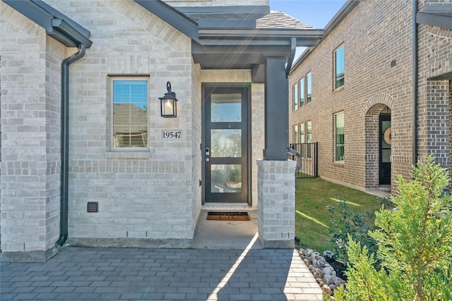 entrance to property featuring brick siding