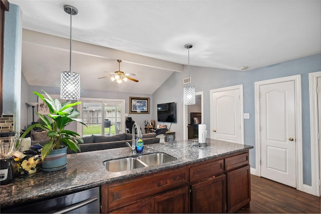 kitchen featuring dishwashing machine, dark stone counters, a sink, dark wood-type flooring, and open floor plan