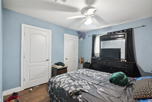 bedroom featuring dark wood-type flooring, baseboards, visible vents, and ceiling fan