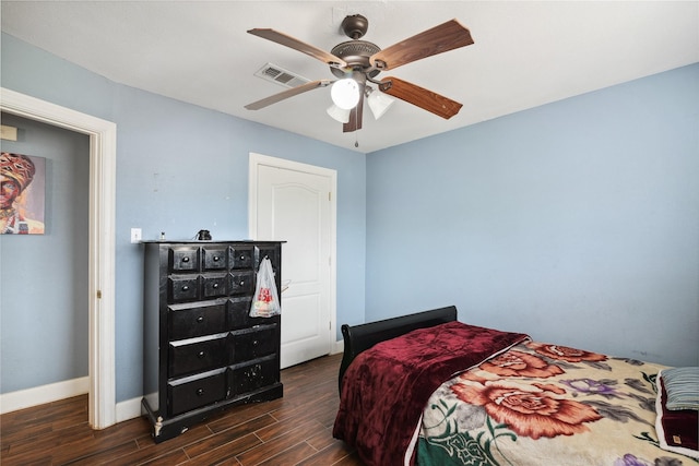 bedroom with dark wood-style floors, visible vents, a ceiling fan, and baseboards