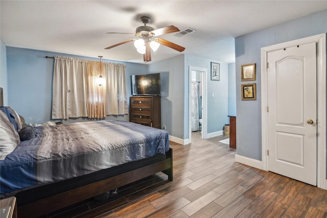 bedroom featuring visible vents, a ceiling fan, baseboards, and wood finished floors