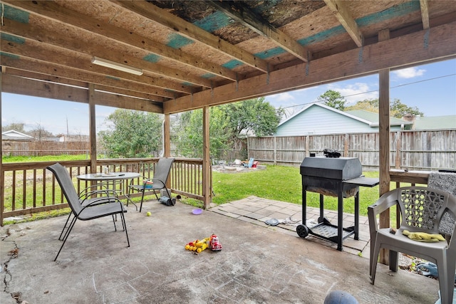 view of patio featuring a grill and fence