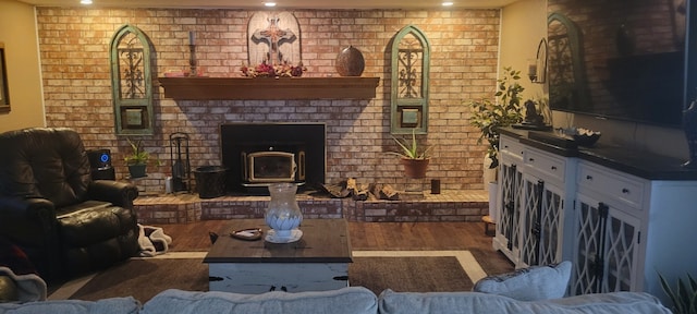 living room with recessed lighting, wood finished floors, and brick wall