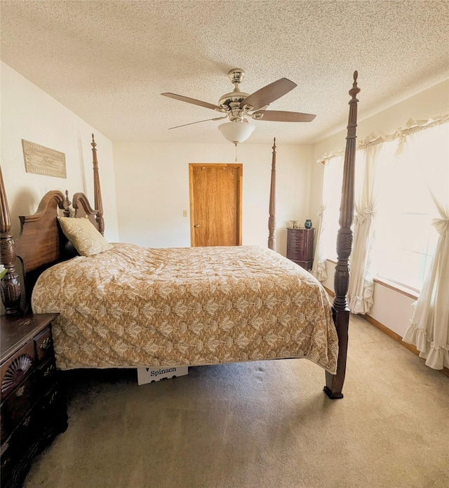 carpeted bedroom with a ceiling fan and a textured ceiling