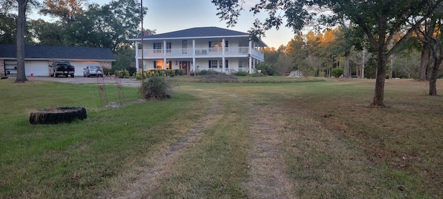 rear view of house featuring a lawn, a chimney, and a balcony