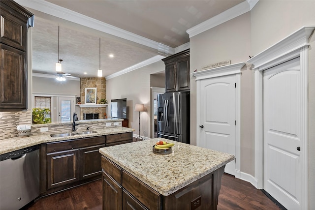 kitchen featuring a sink, appliances with stainless steel finishes, ornamental molding, and dark brown cabinets