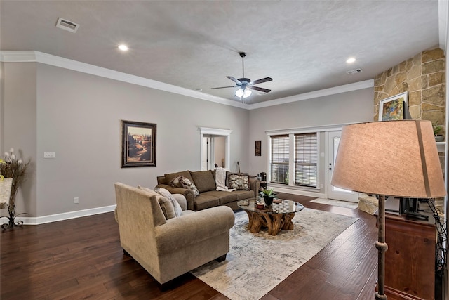 living area featuring visible vents, baseboards, ceiling fan, dark wood-type flooring, and crown molding