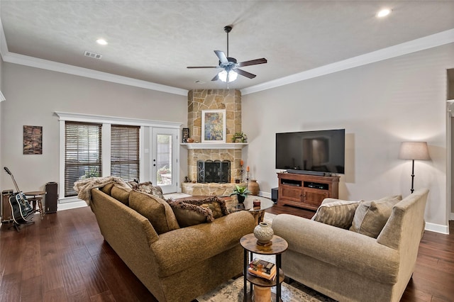 living room featuring visible vents, baseboards, ornamental molding, a fireplace, and dark wood-style floors