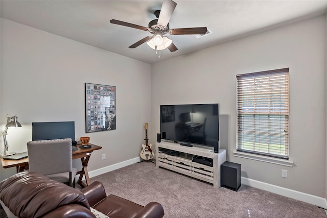 living room featuring a wealth of natural light, a ceiling fan, baseboards, and carpet floors