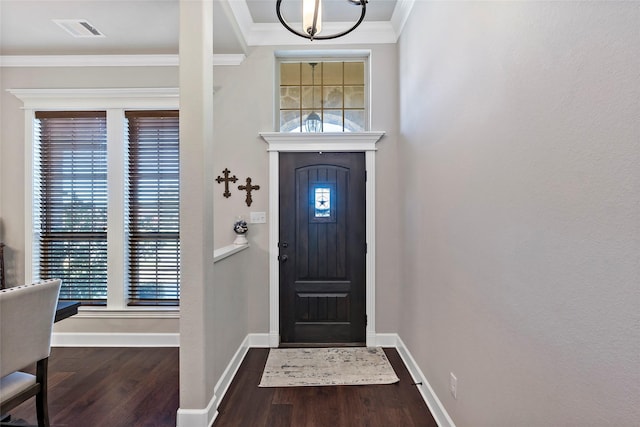 foyer entrance with baseboards, wood finished floors, visible vents, and ornamental molding