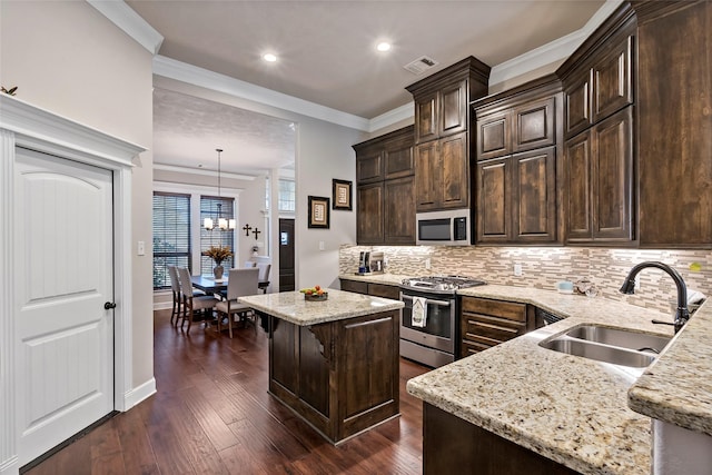 kitchen featuring visible vents, dark brown cabinetry, light stone counters, stainless steel appliances, and a sink