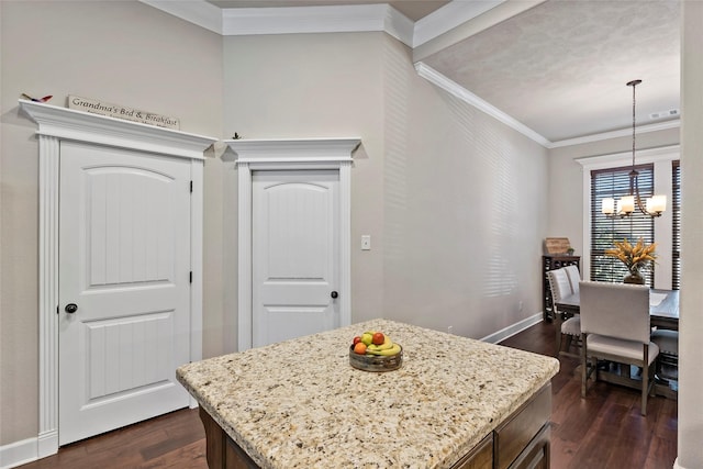 kitchen featuring a notable chandelier, dark wood-style floors, light stone countertops, and ornamental molding