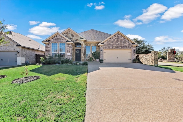 view of front facade featuring driveway, stone siding, a front yard, a garage, and brick siding