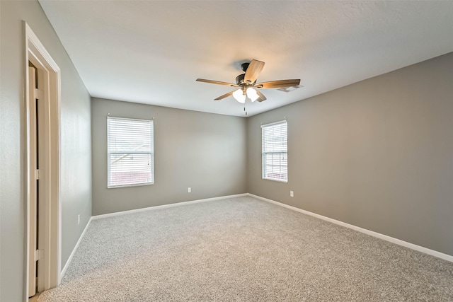 empty room featuring baseboards, light colored carpet, and a healthy amount of sunlight