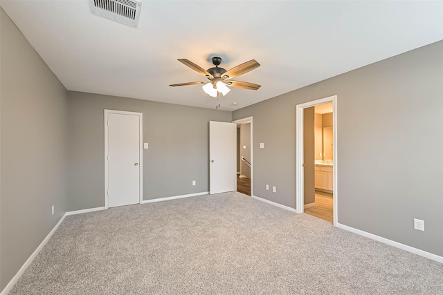 unfurnished bedroom featuring visible vents, baseboards, ceiling fan, light colored carpet, and connected bathroom