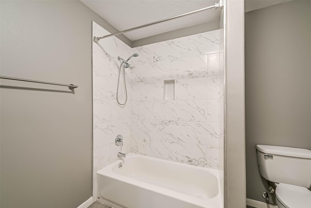 bathroom featuring baseboards, toilet, and  shower combination