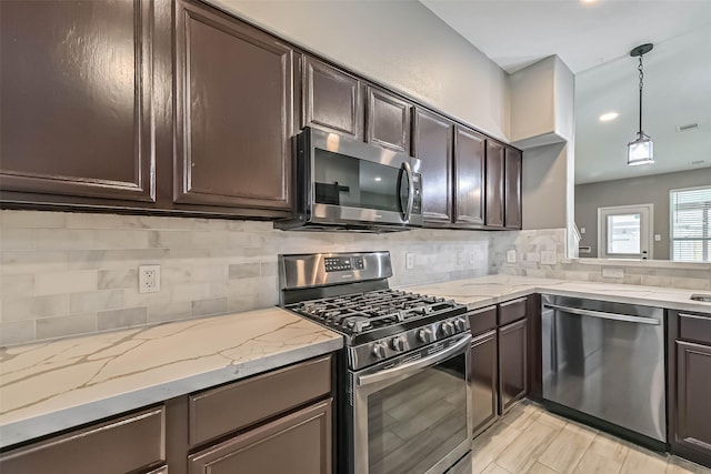 kitchen with dark brown cabinetry, light stone counters, backsplash, and appliances with stainless steel finishes