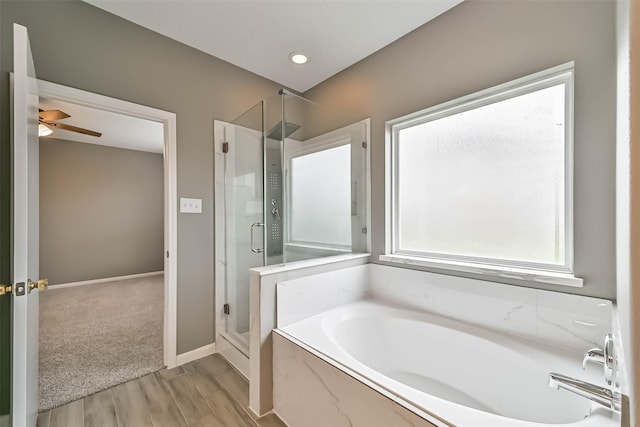 bathroom with baseboards, a garden tub, a stall shower, and a ceiling fan