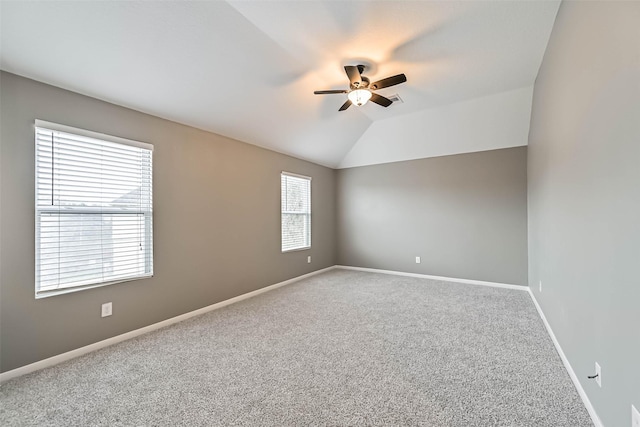 carpeted spare room with baseboards, lofted ceiling, and a ceiling fan