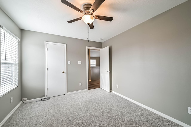 unfurnished bedroom featuring baseboards, carpet, and a ceiling fan