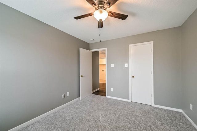 unfurnished bedroom with carpet flooring, a ceiling fan, and baseboards