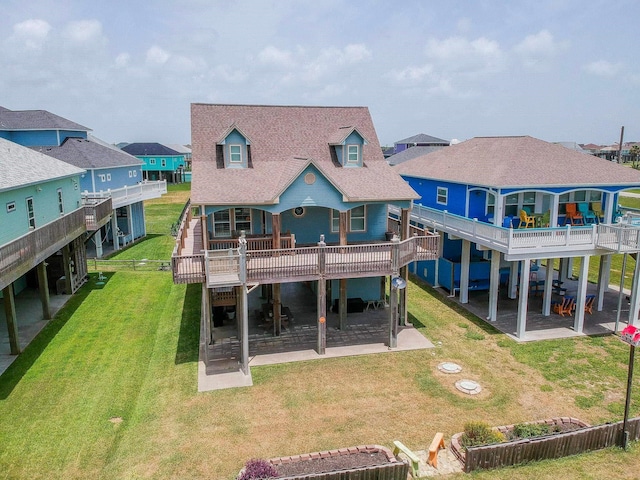 back of property with a residential view, a wooden deck, roof with shingles, a yard, and a patio