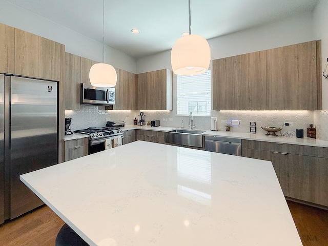 kitchen with tasteful backsplash, stainless steel appliances, modern cabinets, and a sink