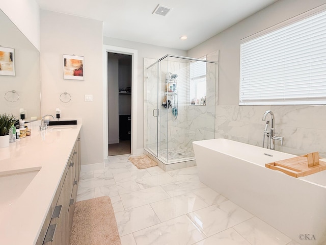 bathroom with visible vents, a freestanding bath, a stall shower, marble finish floor, and a sink