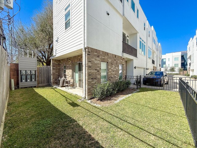 exterior space featuring a yard, a fenced backyard, and brick siding