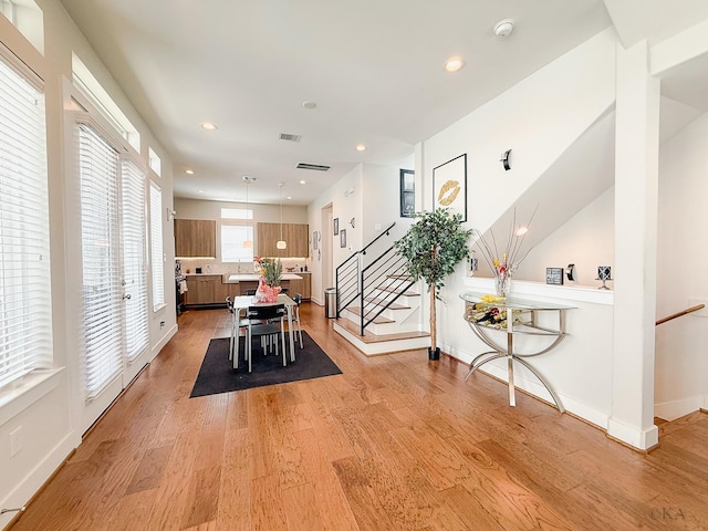 dining room featuring recessed lighting, light wood-type flooring, visible vents, and stairs