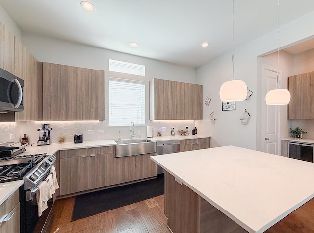 kitchen featuring a sink, modern cabinets, appliances with stainless steel finishes, and light countertops