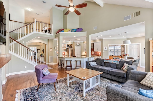 living room with visible vents, stairs, and wood-type flooring