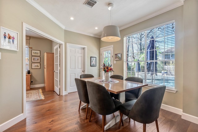 dining area featuring visible vents, crown molding, baseboards, and hardwood / wood-style floors