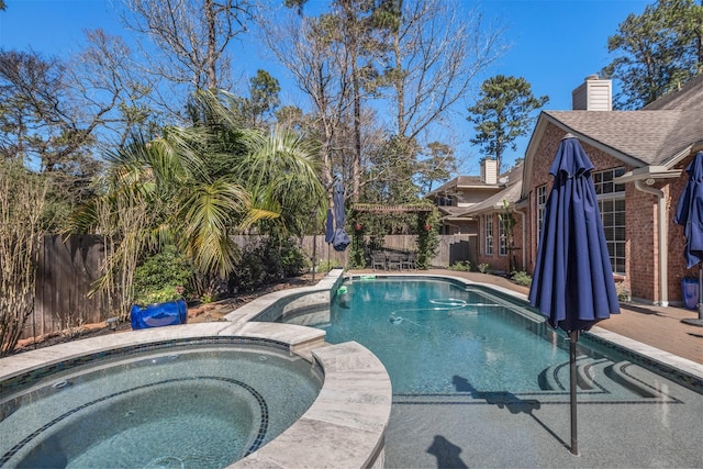 view of swimming pool featuring a fenced backyard and a pool with connected hot tub