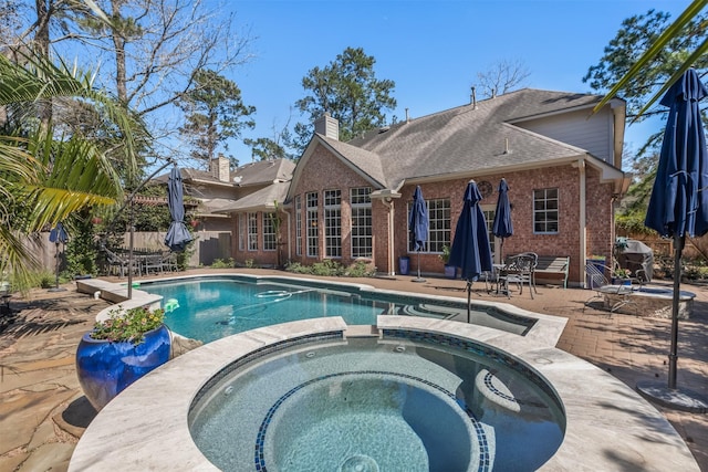 view of pool featuring a patio area, a pool with connected hot tub, and fence