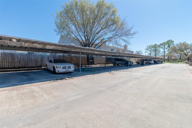 covered parking lot featuring fence