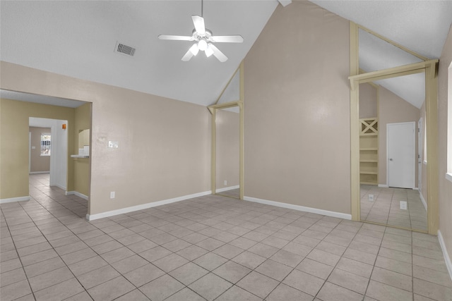 tiled spare room featuring visible vents, baseboards, high vaulted ceiling, and ceiling fan