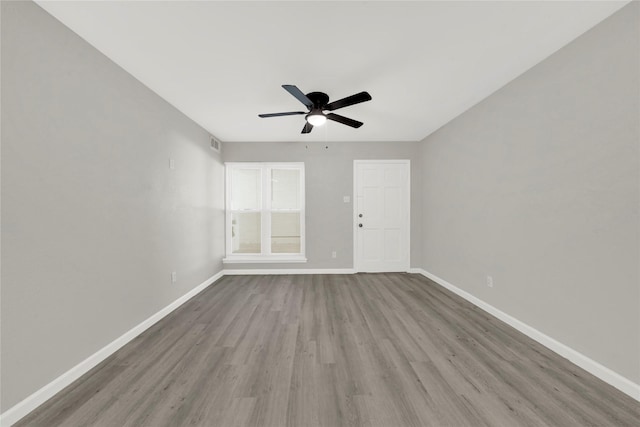 unfurnished room with visible vents, a ceiling fan, baseboards, and wood finished floors