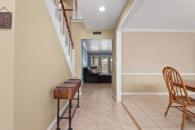 interior space featuring stairs, baseboards, light tile patterned flooring, and crown molding